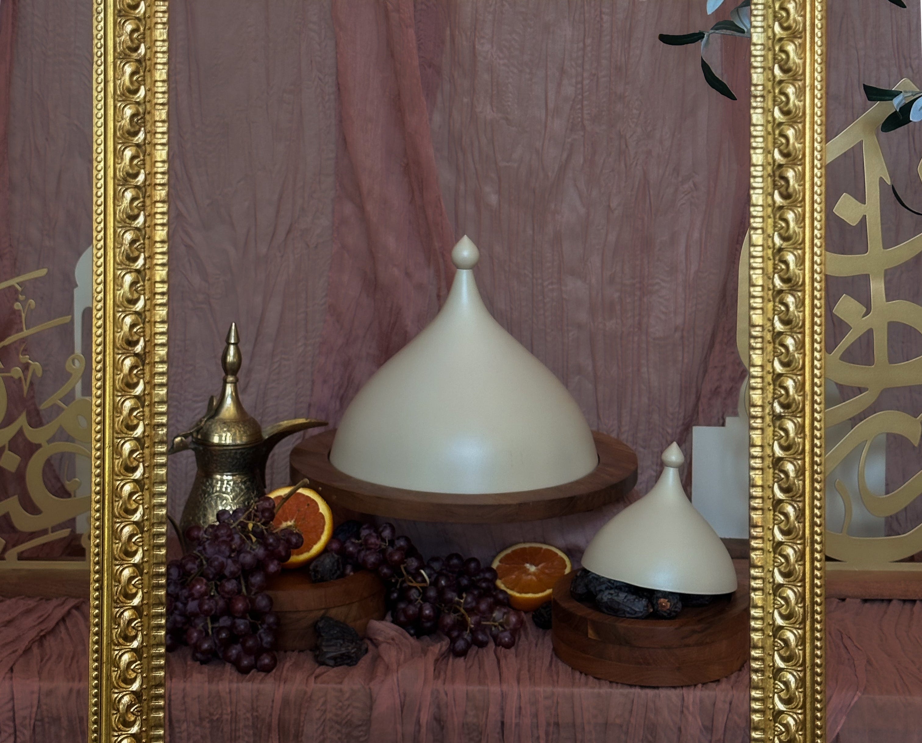 Decorative still life with white lamps, oranges, and coffee beans in a gold frame.